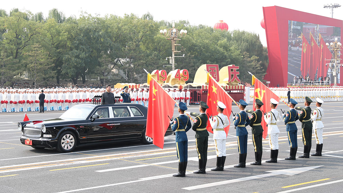 习近平驱车行进至党旗、国旗、军旗前，向旗帜行注目礼